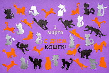 Happy Cat Day in Russia. Orange, black and grey funny cat silhouettes on lilac pastel background. Festive layout for feline holiday, text in Russian 1 MARCH CAT DAY. Flat lay, top view