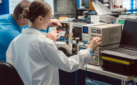 Two electronic engineers on the test bench measuring a new product