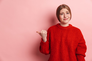Photo of confused nice woman looking at camera and pointing finger aside