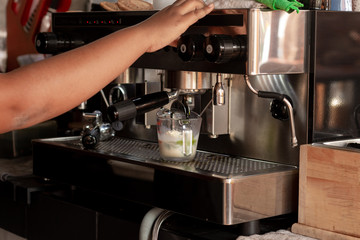 Barista making a milk green tea with a classic coffee machine.