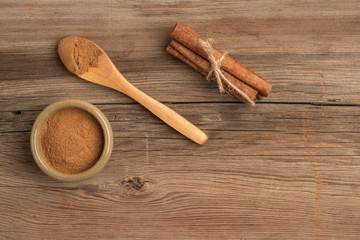 cinnamon powder and sticks on a wooden table with copy space