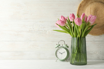 Composition with tulips in vase on wooden background, close up