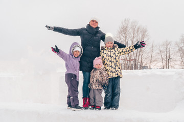 Fototapeta na wymiar Winter family portrait. Mom with three daughters are walking in the park. Family laughing outdoors. Enjoying nature, wintertime.