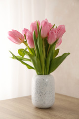 Tulips in vase on wooden background, close up