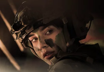 woman soldier hiding and waiting for attack in battle field, with copy space © Siriporn