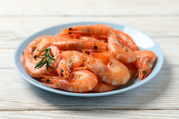 Plate with shrimps on wooden background, close up