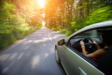 Young beautiful woman driving car - rear view