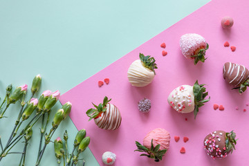 Handmade chocolate covered strawberries and flowers on colored background with free space for text