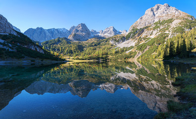 Fototapeta na wymiar pictorial lake Seebensee in the morning, with reflecting mountains in the calm water, austrian landscape