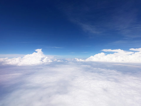 Stunning bloud of aerial view above clouds from airplane window with blue sky, ravelling by air background.