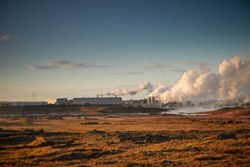 Fototapeta na wymiar Alternative green energy. Geothermal power station pipeline and steam. Plant located at Reykjanes peninsula in Iceland, Europe. Popular tourist attraction. Steaming hot water. Gunnuhver Hot Springs.