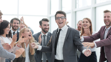 Obraz premium happy young businessman standing in front of his business team.