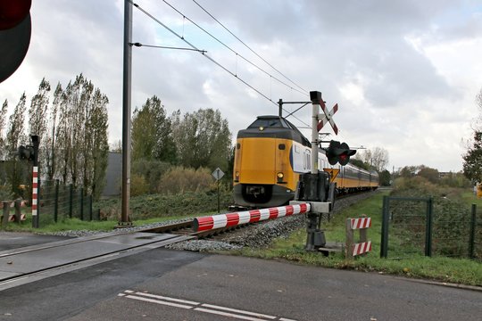 ICM intercity of NS named Koploper at a railroad crossing in Alphen aan den Rijn at single track