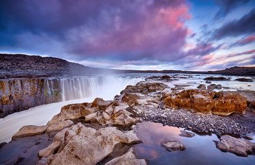 Colorful clouds over Selfoss waterfall. Iceland, Jokulsargljufur National Park, Fjollum river,  Europe. Popular tourist attraction. Travelling concept background. Golden Ring. Beautiful Postcard..