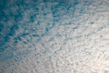 Fluffy gray clouds on a blue background. Abstract pattern background