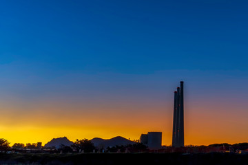 Fototapeta na wymiar Silhouetted Tower, Buildings, at Sunset Sunrise