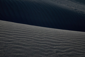 Black Icelandic Basalt Sand. Embossed sandy texture. Wavy background. Abstract pattern. Nature...