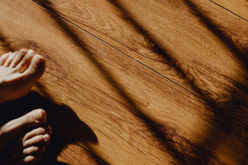 Pieds sur les planches de parquet entre ombre et lumière © lorabarra