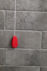 Shower emergency call system with red clip. Emergency cable in the shower with red symbol on a...