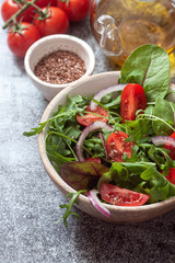 Fresh green mixed salad with cherry tomatoes in a wooden bowl