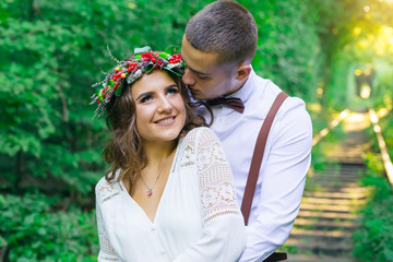 Obraz premium The guy hugs a girl from the back side and wants to kiss. girl w