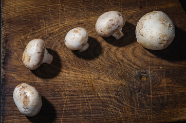 Obraz na płótnie Canvas fresh mushrooms on an old wooden board