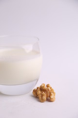 glass of walnut milk in color background