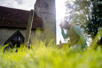 A young man grieving in the old graveyard