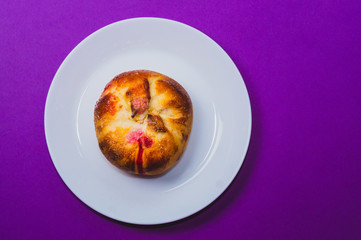 Bun with red sweet jam. sweet baking close up