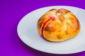 Bun with red sweet jam. sweet baking close up