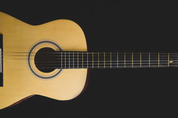 Acoustic guitar on the black background. musical instrument
