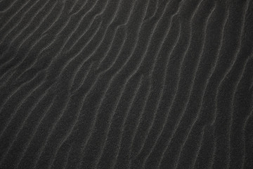Black Icelandic Basalt Sand. Embossed sandy texture. Wavy background. Abstract pattern. Nature...