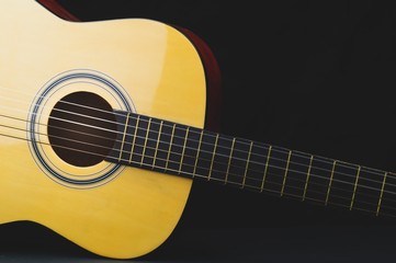 Naklejka na ściany i meble Acoustic guitar on the black background. musical instrument