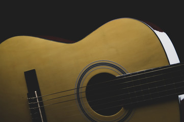 Acoustic guitar on the black background. musical instrument