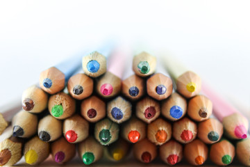 Color pencils lie on a white sheet of paper