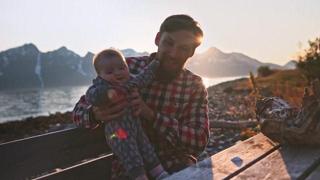 Father traveling with baby in Norway  family vacation dad and child playing outdoors active healthy lifestyle mountains and fjord landscape