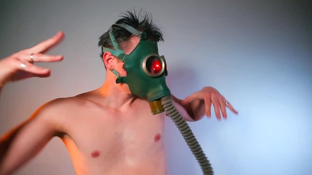 A masked man makes dance moves at a nightclub party.