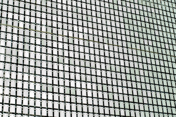 The building is made of metal. Glass wall. Wall of metal tiles.