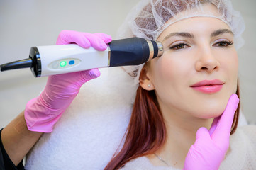 Portrait of a middle-aged woman receiving a non-surgical rejuvenation procedure at a cosmetologist....