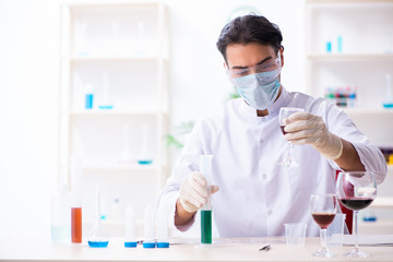 Fototapeta premium Male chemist examining wine samples at lab