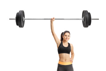 Obraz premium Strong young woman lifting a barbell with one hand