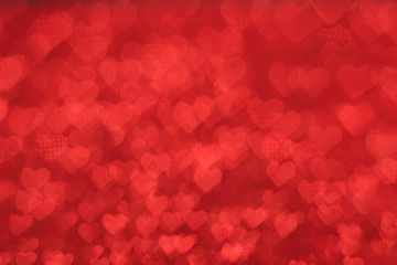 The bokeh texture in the form of many small hearts on a red background. Valentine's day concept.