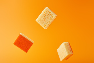 yellow falling sponges for dish washing isolated on orange