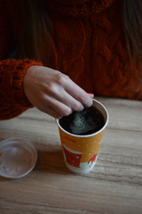 glass of coffee in hand, oranges sweater