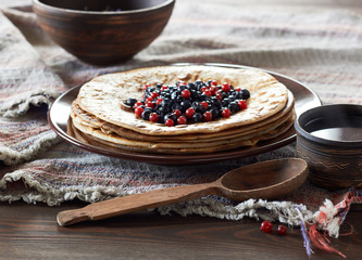 Pancake week hot cakes with berries, honey, butter and cup of tea on rustic background, closeup, copy space, shrovetide and homemade food concept