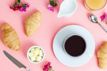 Morning breakfast coffee and croissant, butter, orange juice and flowers on white background. Flat lay, top view