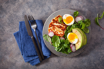 healthy keto paleo diet breakfast: boiled egg, avocado, halloumi cheese, salad leaves