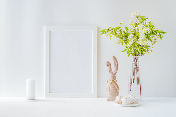 Home interior with easter decor. Mockup with a white frame and spring flowers in a vases on a light background