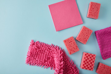 top view of pink rags and sponges for house cleaning on blue