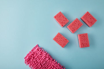 top view of pink household goods for house cleaning on blue